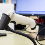 Barcode-Scanner am Arbeitsplatz als Symbol für inventarisierte Endpoint-Bestände