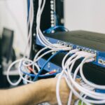 Techniker arbeitet an Netzwerkverkabelung in einem Serverraum