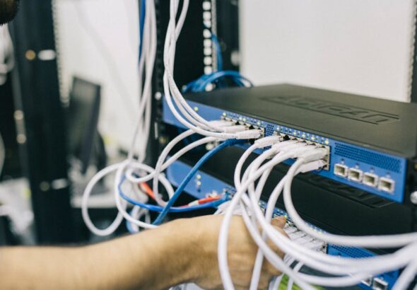 Techniker arbeitet an Netzwerkverkabelung in einem Serverraum