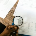 Lupe über Dokumenten als Symbol für Audit, Prüfung und Datenaufsicht