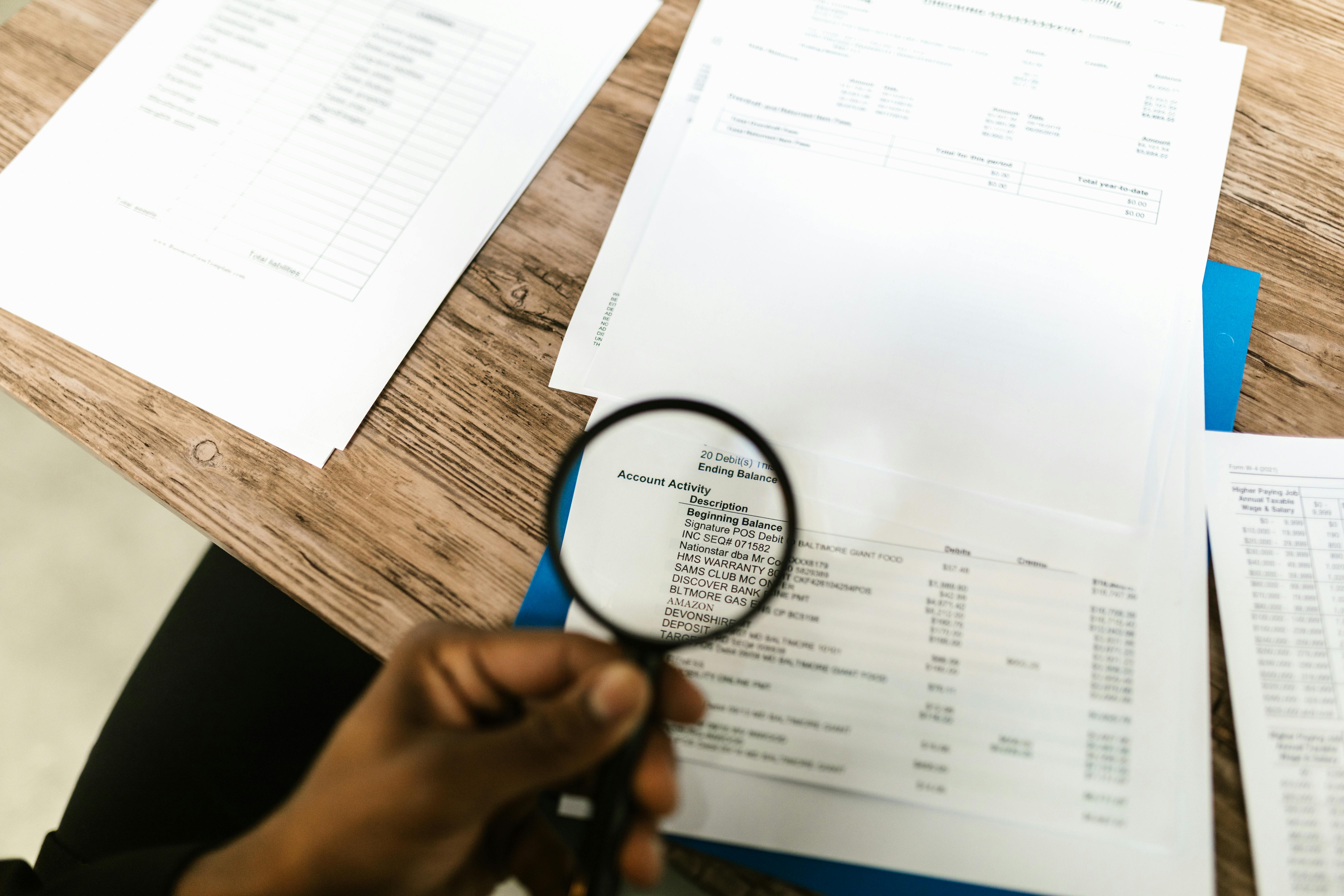 Lupe über Dokumenten als Symbol für Audit, Prüfung und Datenaufsicht