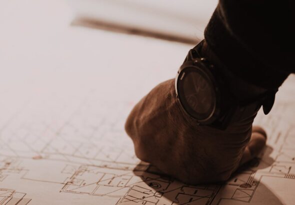 Hand auf Bauplan als Sinnbild für COBIT-Governance-Design