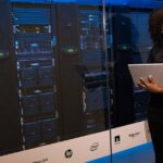 Software Engineer beside server racks for vulnerability and patch operations
