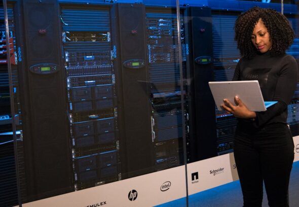 Software Engineer beside server racks for vulnerability and patch operations