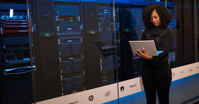 Software Engineer beside server racks for vulnerability and patch operations