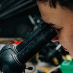 Techniker prüft eine Leiterplatte unter dem Mikroskop als Sinnbild für Produktsicherheit über den Supportzyklus hinweg