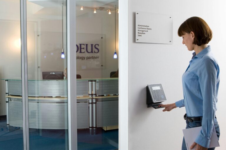 Frau scannt ihren Finger an einem biometrischen Zugangssystem in einer modernen Büroumgebung