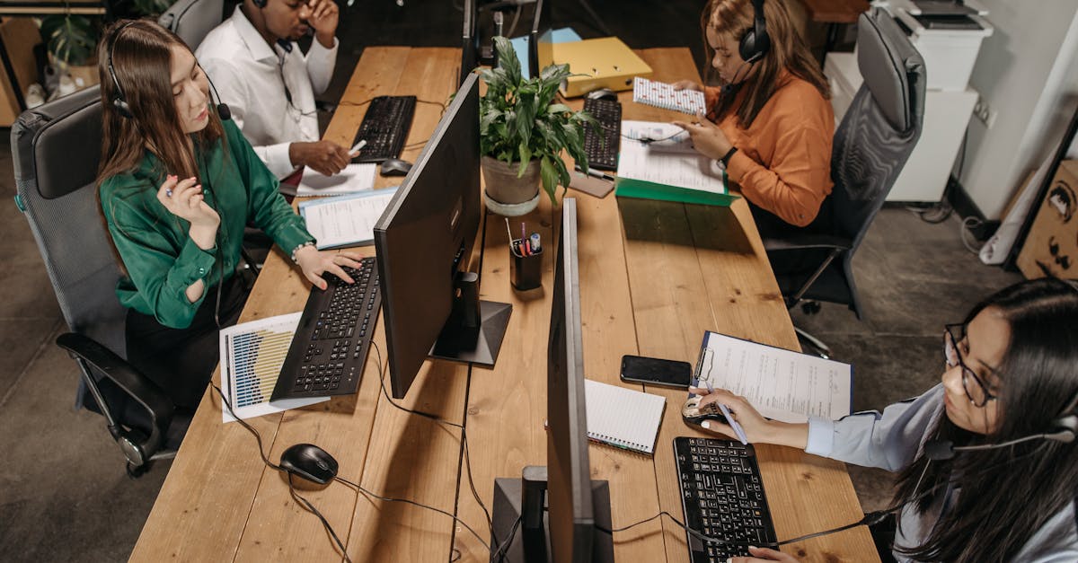 Service-Desk-Team arbeitet mit Headsets und Monitoren im Großraumbüro