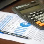 Finanzanalyse mit Taschenrechner und Kostenbericht als Symbol für FinOps und Cloud-Kostensteuerung