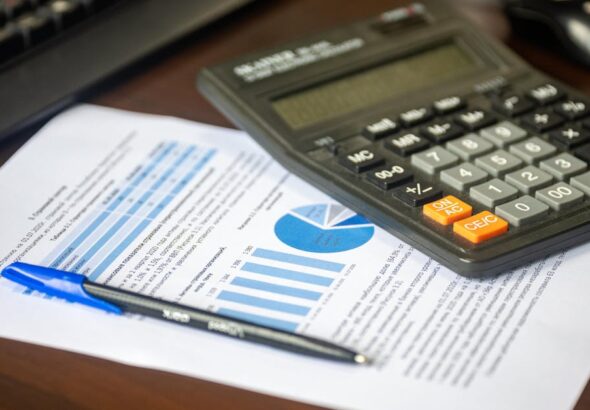 Finanzanalyse mit Taschenrechner und Kostenbericht als Symbol für FinOps und Cloud-Kostensteuerung
