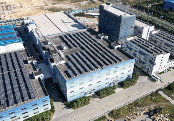 Luftaufnahme eines Industrie- oder Rechenzentrumsstandorts mit großflächigen Solaranlagen auf den Dächern als Symbol für GreenOps, Cloud-Nachhaltigkeit und CO2-Reporting