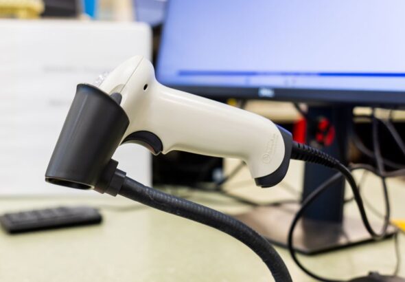 Barcode-Scanner am Arbeitsplatz als Sinnbild fuer Asset-Bezug und Inventarisierung