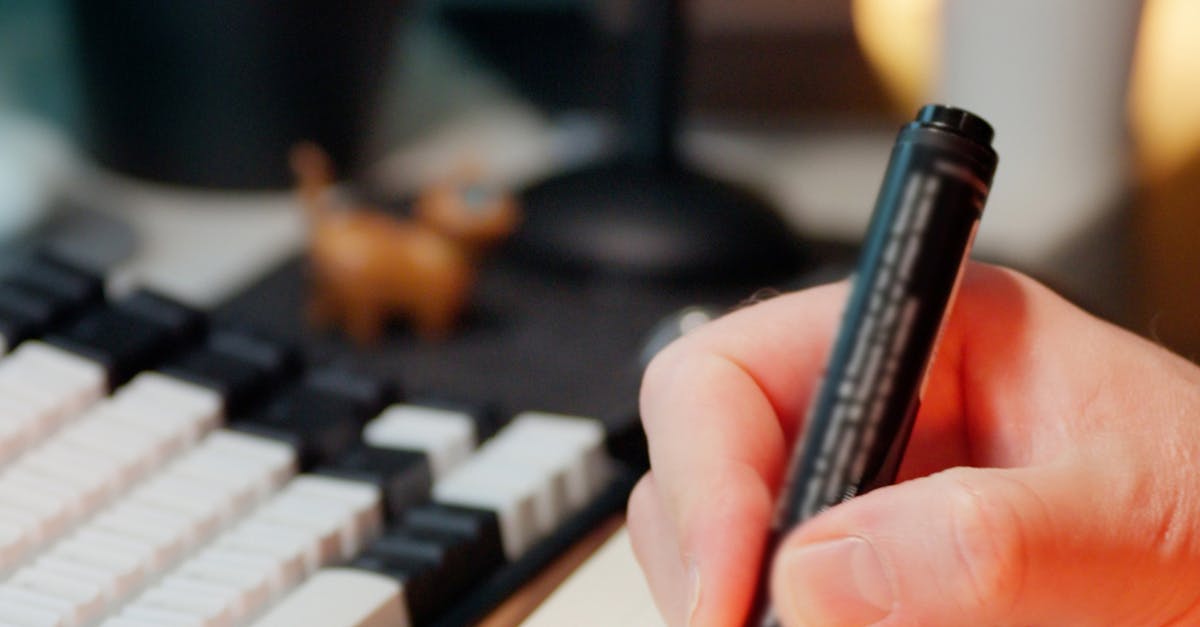 Hand markiert Aufgaben in einem Notizbuch neben einer Tastatur als Symbol für dokumentierte KI-Kompetenz und Betriebsleitplanken