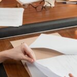 Zwei Fachleute prüfen Dokumente am Schreibtisch als Symbol für Rechte- und Content-Governance in Microsoft 365 Copilot