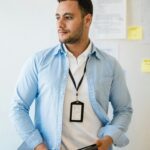 Mitarbeiter mit Badge und Dokumenten als Symbol fuer Agentenidentitaet und Zugriffsrechte