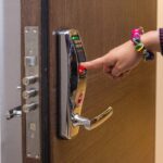 Hand mit Fingerprint-Zugang an digitalem Türschloss
