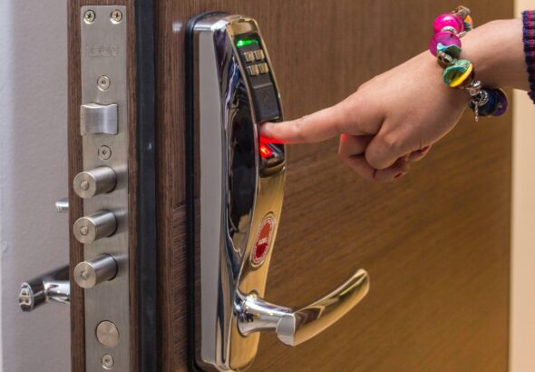 Hand mit Fingerprint-Zugang an digitalem Türschloss