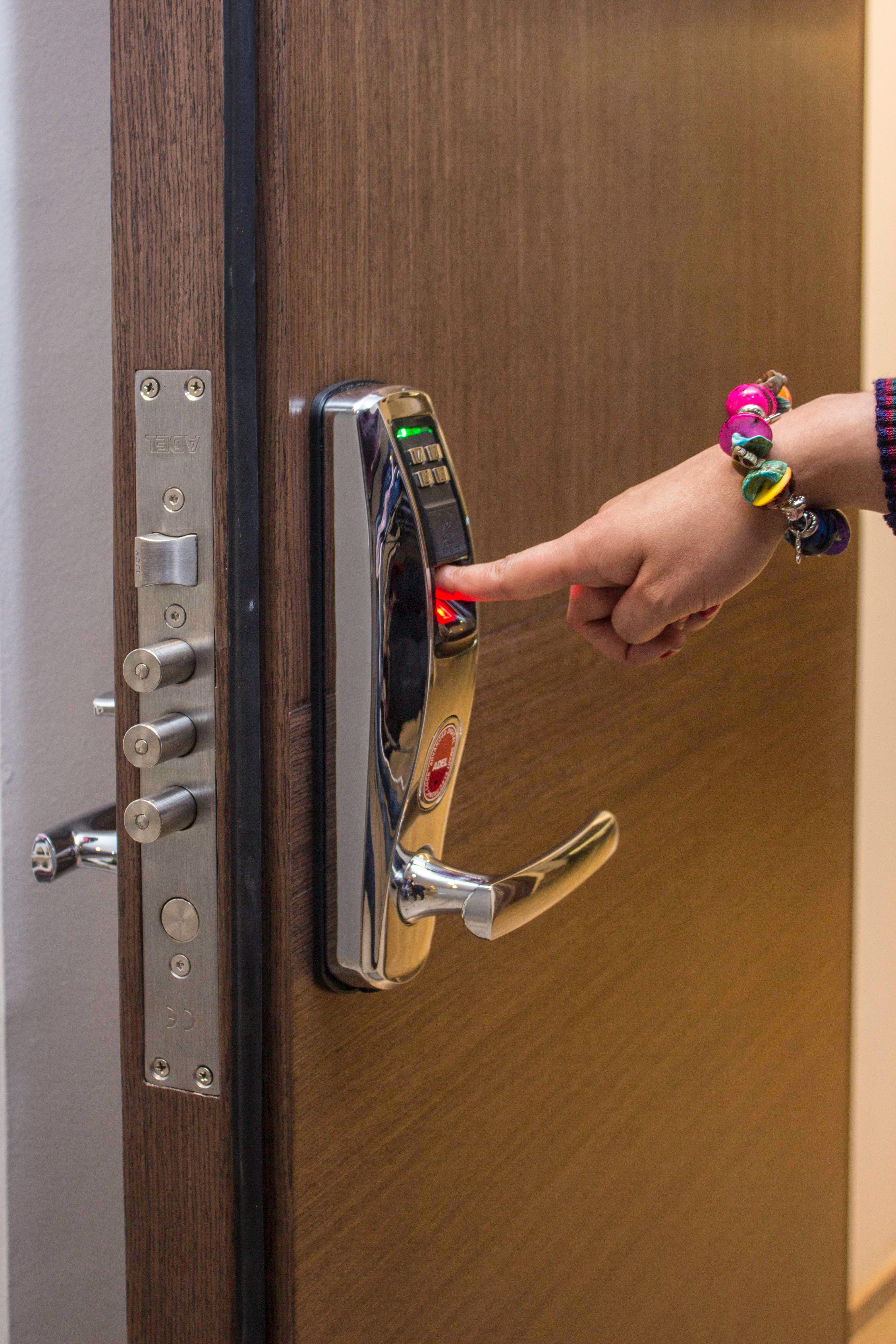 Hand mit Fingerprint-Zugang an digitalem Türschloss