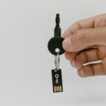 Hand hält Schlüssel mit USB-Anhänger als Motiv für Passkey-Recovery und digitale Identität