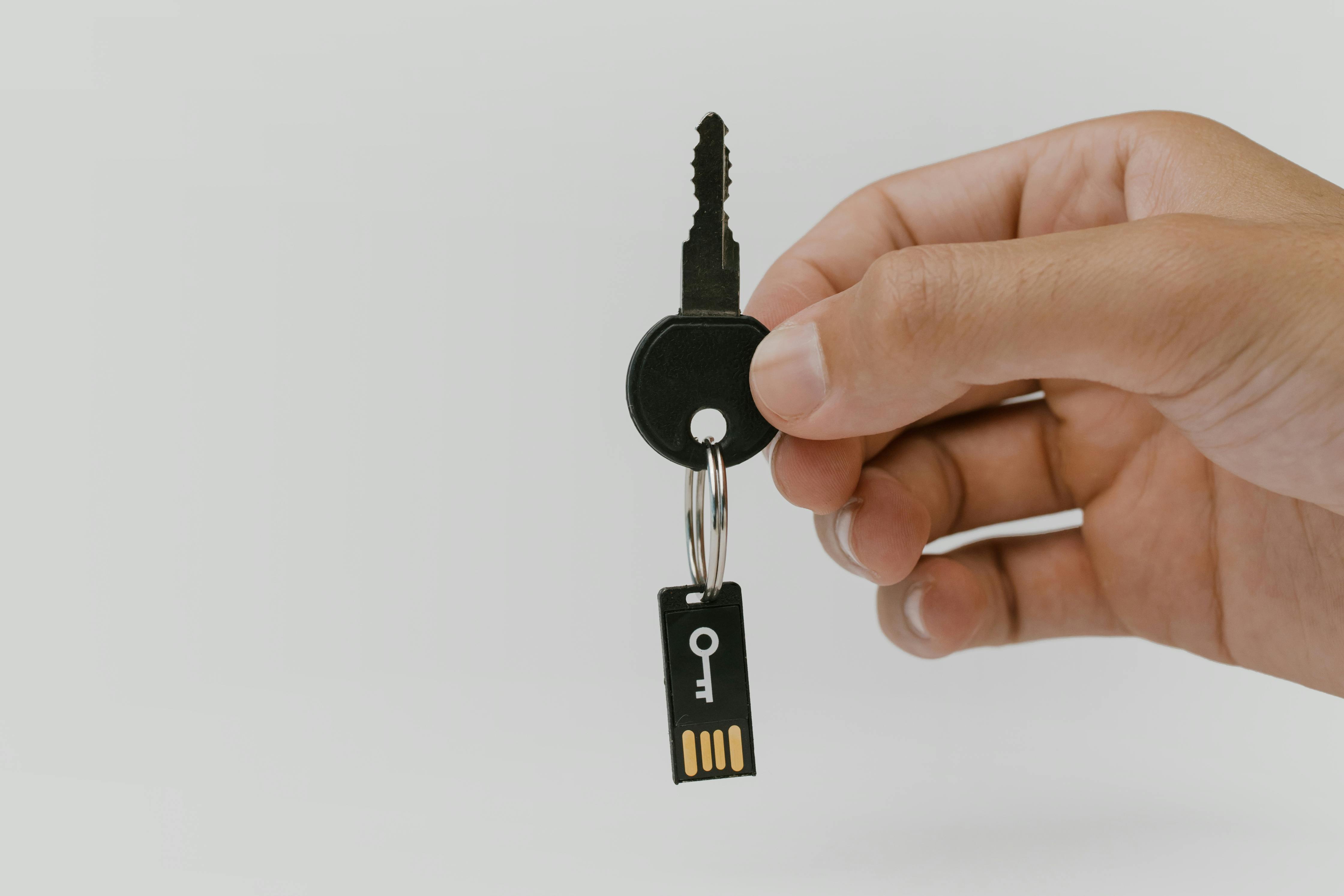 Hand hält Schlüssel mit USB-Anhänger als Motiv für Passkey-Recovery und digitale Identität