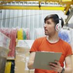 Lagerarbeiter prüft Inventar in einem Regalgang als Sinnbild für SBOM-Transparenz und Software-Bestandsführung