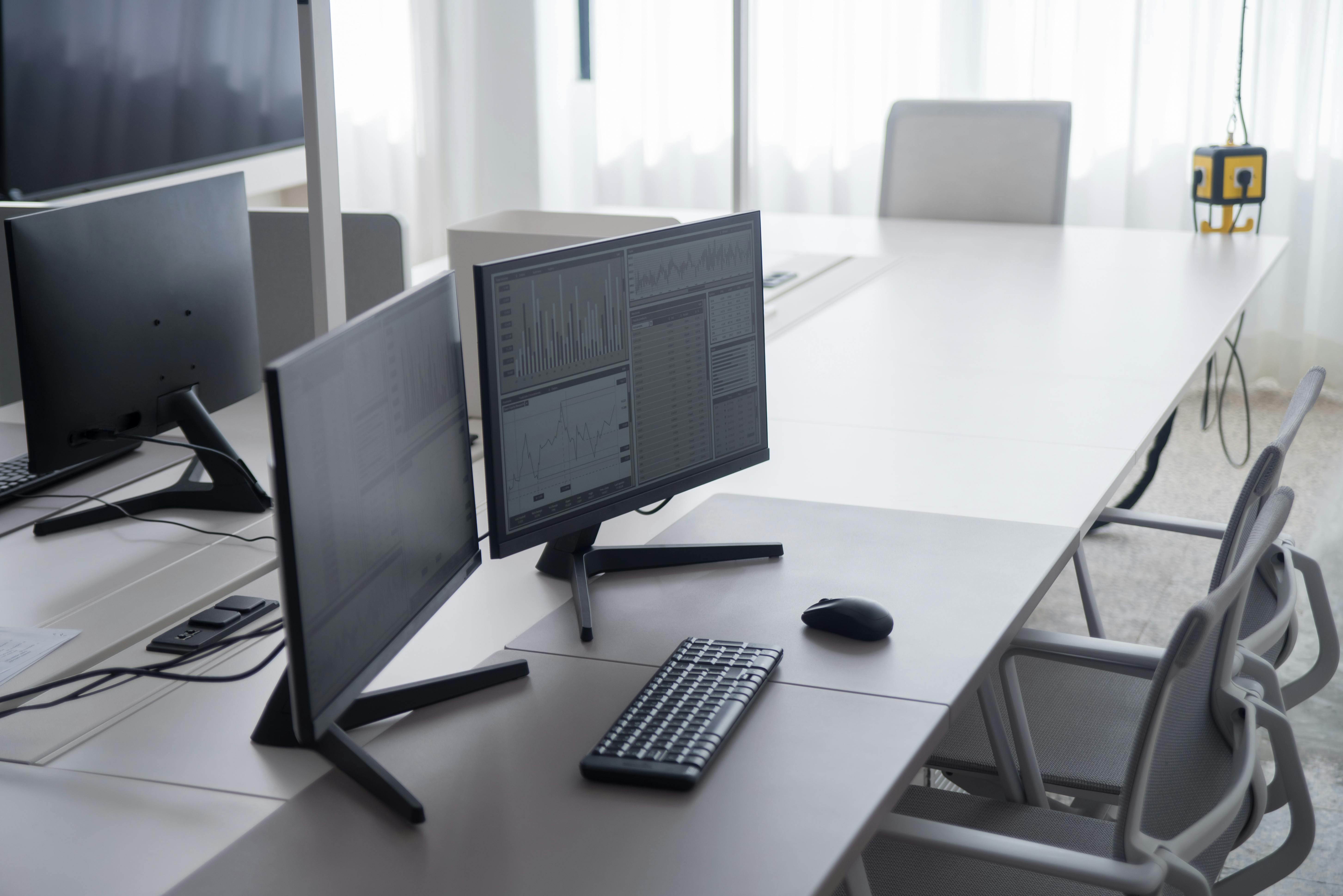 Computerarbeitsplaetze mit Monitoren und Charts im Buero