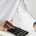 FinOps-Analyse mit Taschenrechner und Unterlagen am Schreibtisch