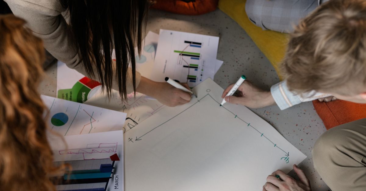 Menschen planen eine Rückfallroute für einen SaaS-Dienst anhand von Diagrammen