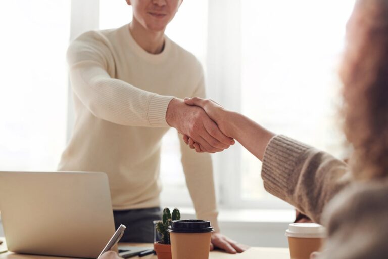 Handshake im Büro als Symbol für vereinbarte Serviceprozesse und Zertifizierung