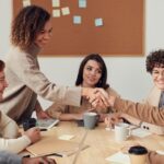 Menschen an einem Besprechungstisch als Symbol für zentrale Rollen- und Rechtepflege in GitHub Enterprise Teams