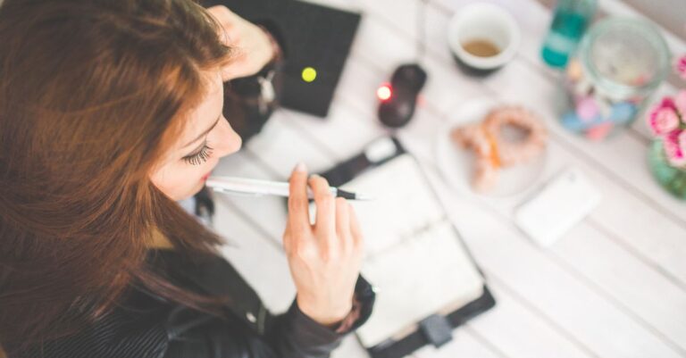 Person mit Notizbuch und Stift als Symbol für Schulung und Praxisfälle im IT-Betrieb