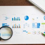 Diagramme mit Lupe als Symbol für Prüfspuren, Auswertung und kontrollierte Entscheidungen im IT-Service