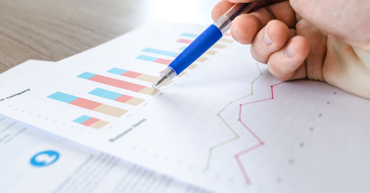 Hand mit Stift über Diagrammen als Symbol für Portfolioentscheidung, Kostensteuerung und Abschaltplanung