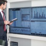 Mitarbeiter prüft große Monitore mit Kennzahlen als Symbol für KI-Entscheidungen und Ticketnachweise im Service Desk