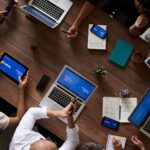Krisenmeeting mit mehreren Geräten und Notizen als Symbol für Major Incident Prozess, Lageführung und Rollenklärung im IT-Betrieb