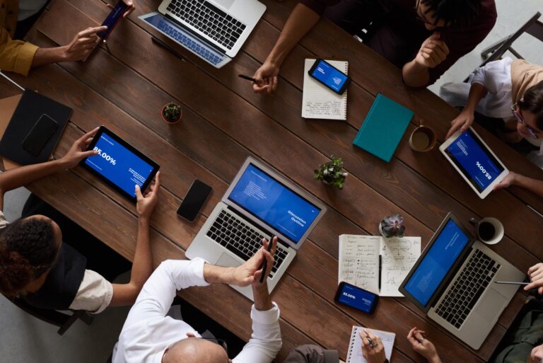 Krisenmeeting mit mehreren Geräten und Notizen als Symbol für Major Incident Prozess, Lageführung und Rollenklärung im IT-Betrieb