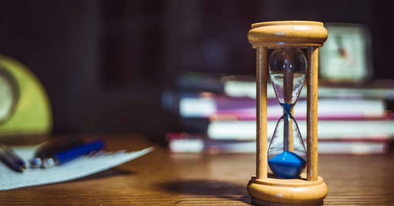 Sanduhr auf einem Schreibtisch als Symbol für Wartezeit, Servicelevel und Kundenerwartung im Support