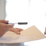 Person zeigt mit Stift auf ein Dokument als Symbol für Ticket-Freigaben, Audit-Nachweis und nachvollziehbare Entscheidungen