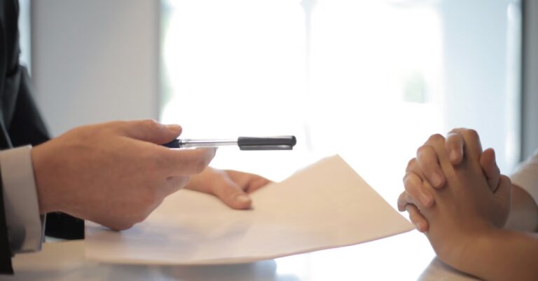 Person zeigt mit Stift auf ein Dokument als Symbol für Ticket-Freigaben, Audit-Nachweis und nachvollziehbare Entscheidungen