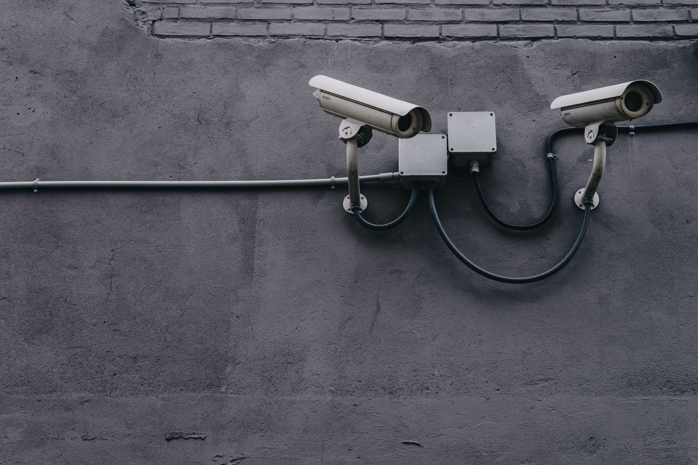 Überwachungskameras an einer Außenwand als Symbol für Gebäudetechnik-Warnungen und Ticketnachweis im ITSM-Betrieb