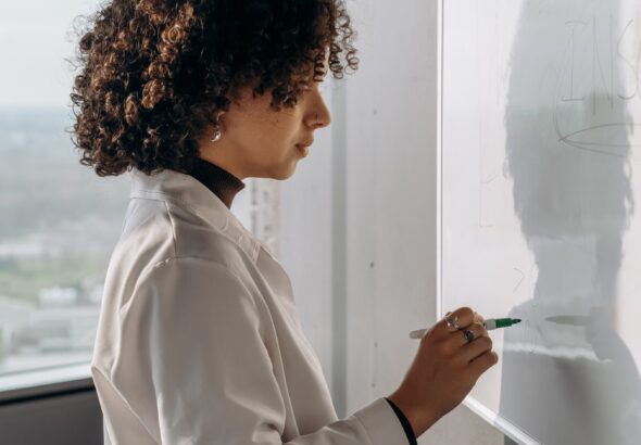 Person erklärt eine Arbeitsliste an einem Whiteboard für ITIL-Practice-Auswahl im IT-Betrieb