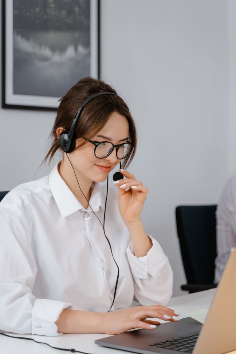 Service-Desk-Mitarbeiterin mit Headset am Laptop als Symbol für Warnungen, Ticketannahme und Nachweise im IT-Betrieb