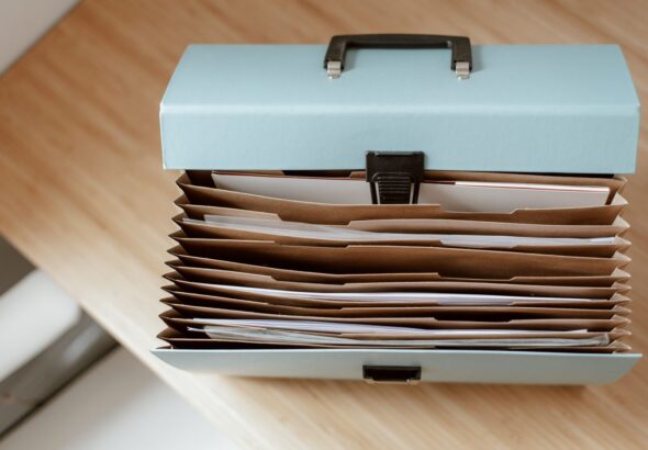 Aktenbox mit sortierten Dokumenten als Symbol für Ticket-Anhänge, Aufbewahrung und Governance im Service Desk
